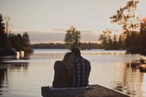 man and woman looking at lake